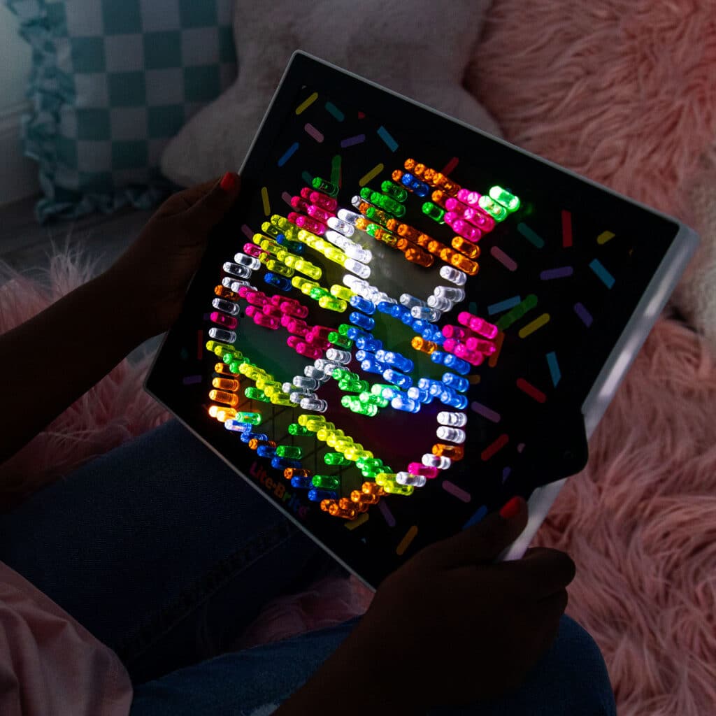 The Lite-Brite Classic, Bold & Bright Edition glowing in the dark displaying an ice cream design