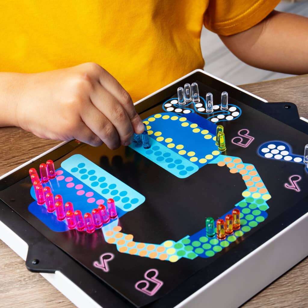 Little kid playing with the Lite-Brite Classic, Bold & Bright Edition making a headphones design