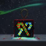 Lite-Brite Mini, Holiday Edition lit up in the dark displaying two candy canes