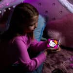 Little girl holding the Lite-Brite, Hello Kitty Mini in the dark as it glows