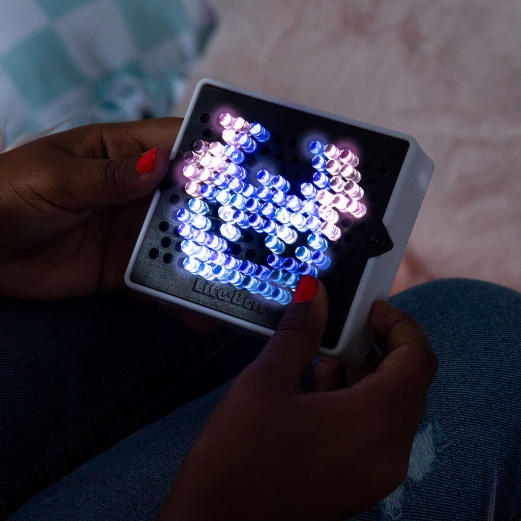 Someone holding the Lite Brite Mini, Stitch in the dark lit up