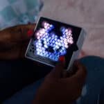 Someone holding the Lite Brite Mini, Stitch in the dark lit up