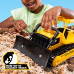 Kid playing with the Tonka Retro Bull Dozer in the rock