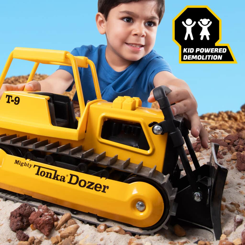 Kid playing with the Tonka Retro Bull Dozer in the rock