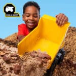Little boy playing with the Tonka - Next Gen Mighty Dump Truck in the rock
