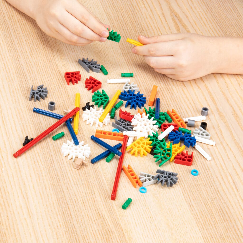Someone building a creation using the pieces from the K'NEX 80 Model Building Set