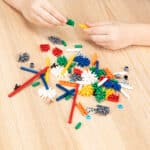 Someone building a creation using the pieces from the K'NEX 80 Model Building Set