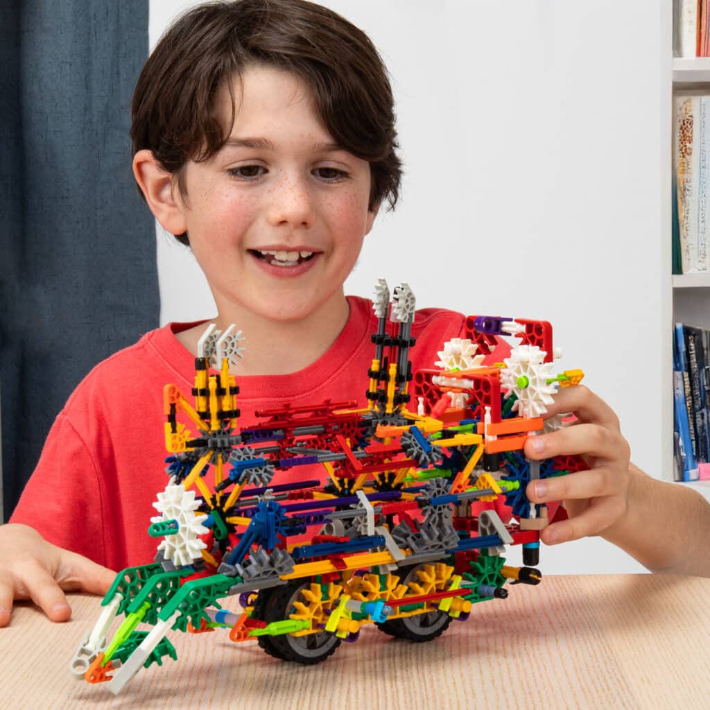 Little boy playing with his creation built from the K'NEX 80 Model Building Set