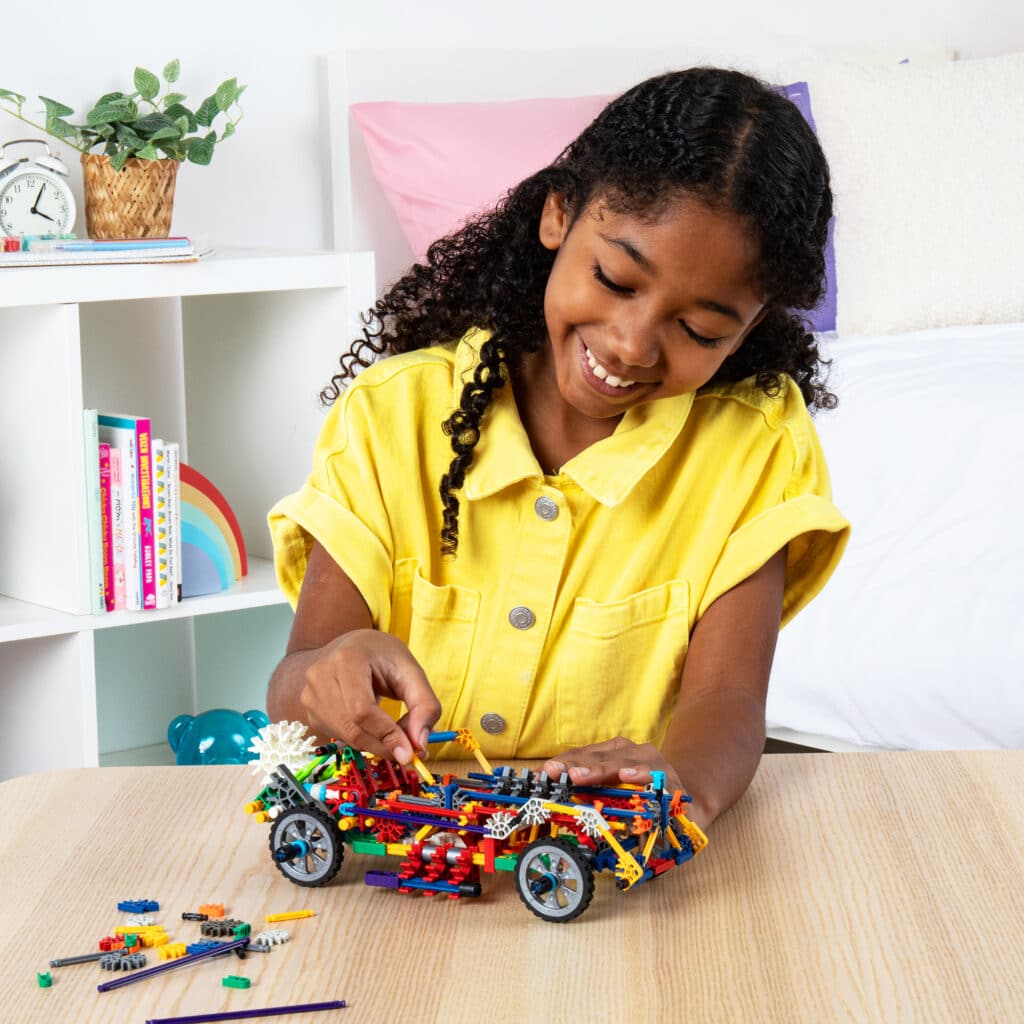 Little girl playing with a custom car built from the K'NEX 80 Model Building Set