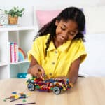 Little girl playing with a custom car built from the K'NEX 80 Model Building Set