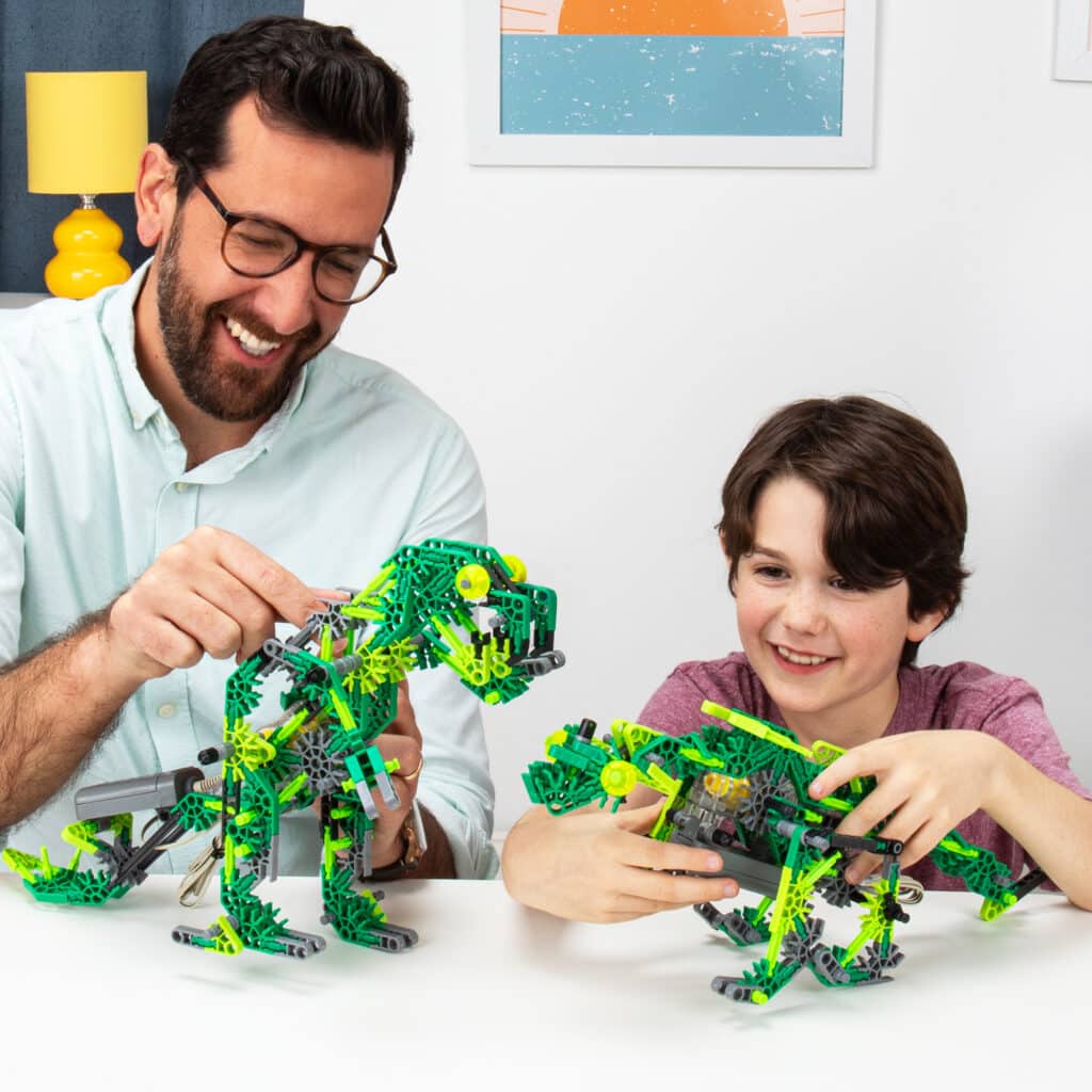 Father and son playing with two dinos built from the K'NEX Dynamic Dinos 6-in-1 Building Set