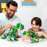 Father and son playing with two dinos built from the K'NEX Dynamic Dinos 6-in-1 Building Set