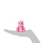 Size scale of how big the bears are in comparison to a hand from the Micro Teenies Care Bears Assortment - Tiny Collectible Plush!