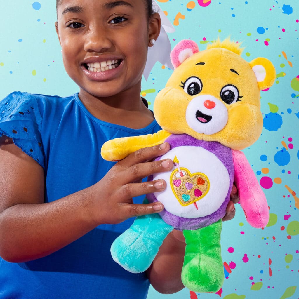 Little girl playing with the Work of Heart Bear from the Fun Size Sparkle Collection