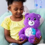 Little girl playing with Cozy Share Bear