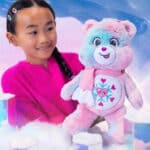 Little girl playing with the Care Bears Collector's Edition Snowflake Sparkle Bear