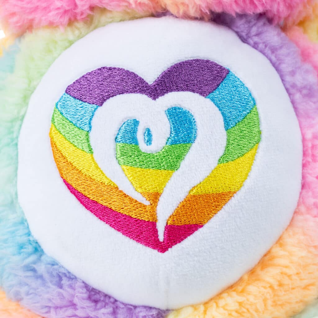 Close up of the Belly Badge on Care Bears Medium Cozy Togetherness Bear Plush