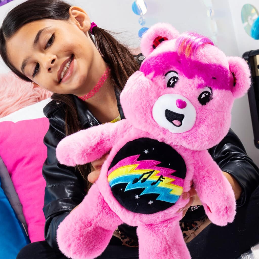 Little girl playing with Care Bears - 14" Medium Plush - Rock-a-Lot Cheer Bear