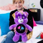 Child playing with Care Bears - 14" Medium Plush - Rock-a-Lot Share Bear