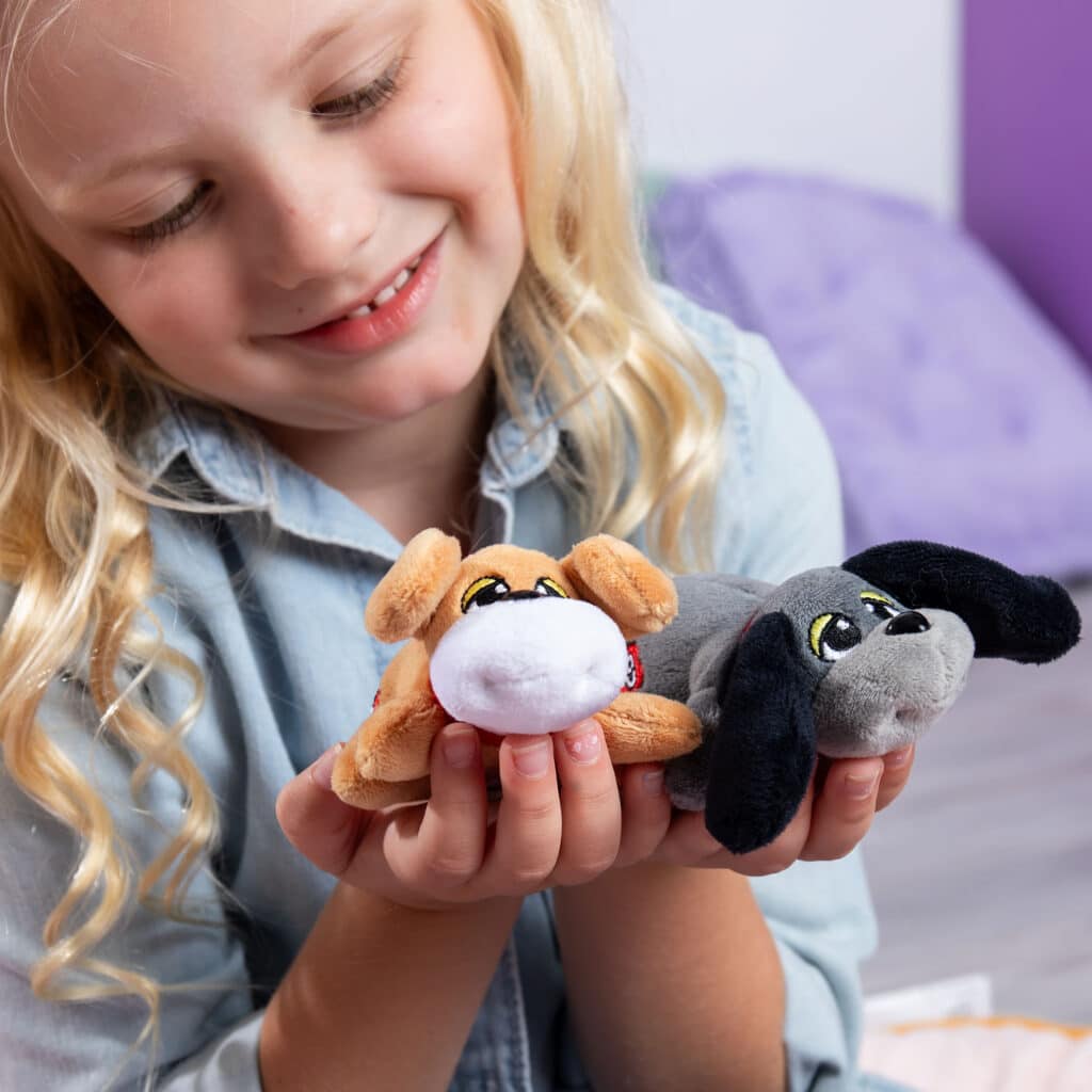 Little girl playing with the Mini Classics, Pound Puppies Mini 2-Pack, Tan & Gray
