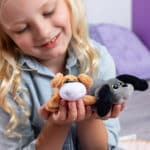 Little girl playing with the Mini Classics, Pound Puppies Mini 2-Pack, Tan & Gray