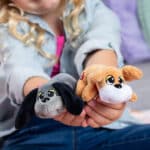 Little girl holding the Mini Classics, Pound Puppies Mini 2-Pack, Tan & Gray
